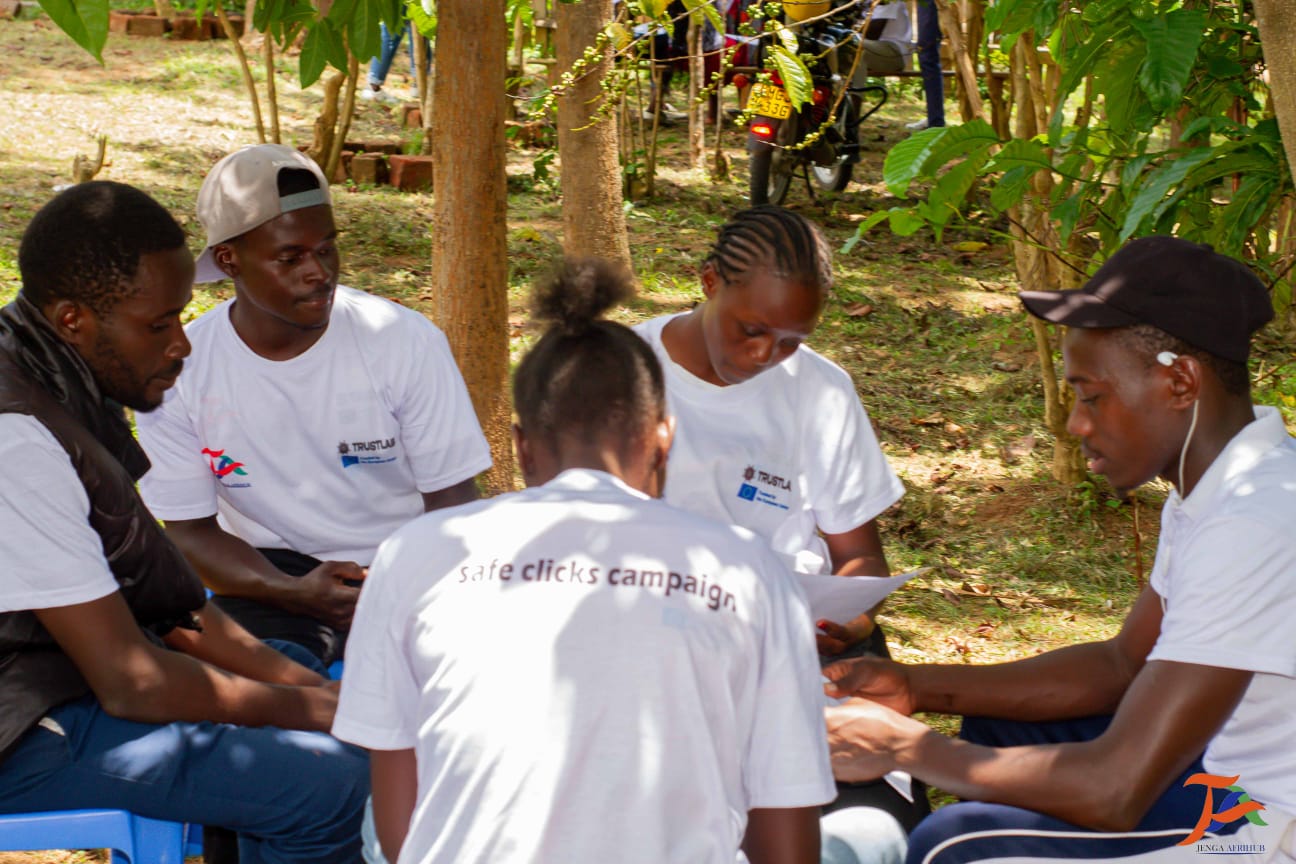 Youth peer learning group reviewing Safe Clicks materials outdoors